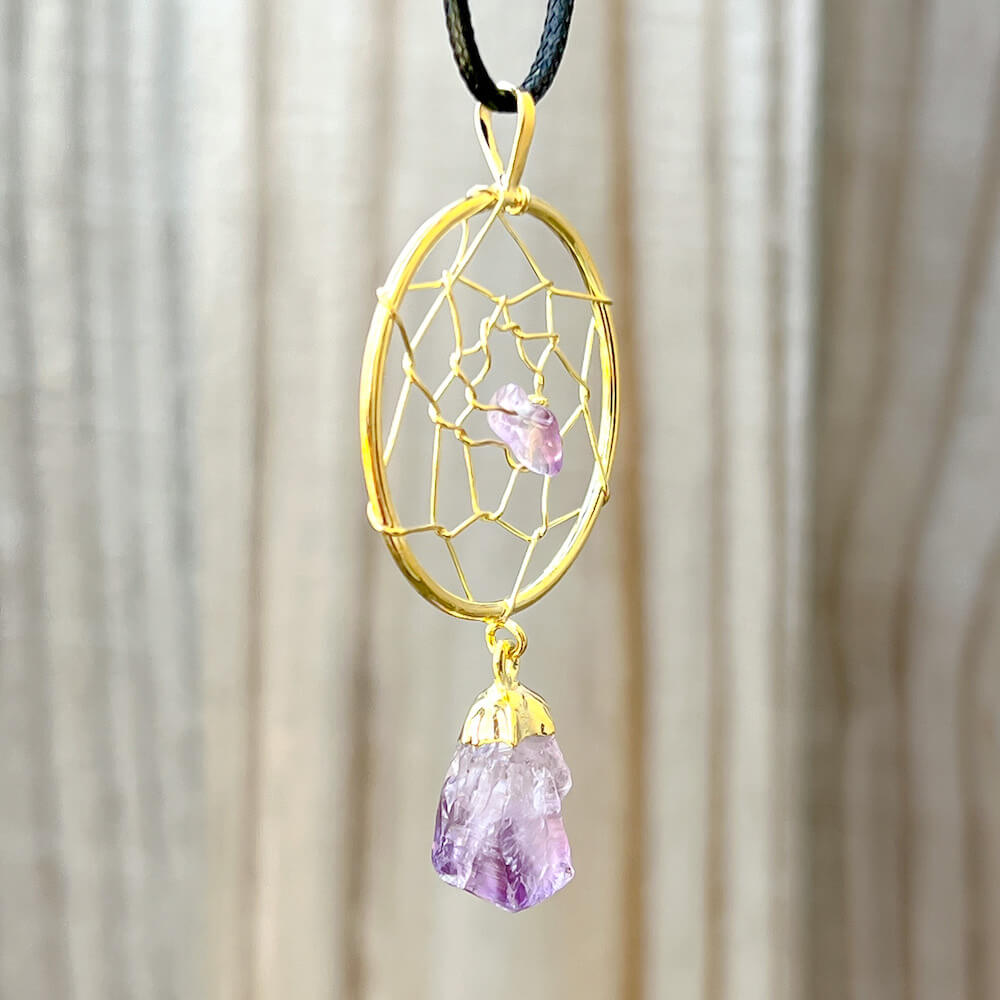 Gorgeous gold plated Amethyst Dreamcatcher gold Necklace adorned with an Amethyst crystal bead and a raw Amethyst crystal hanging from the bottom. Shop at Magic Crystals for Amethyst Jewelry, Healing Crystals, and Stones. Perfect gift for someone or to wear every day. Boho Jewelry, February Birthstone.