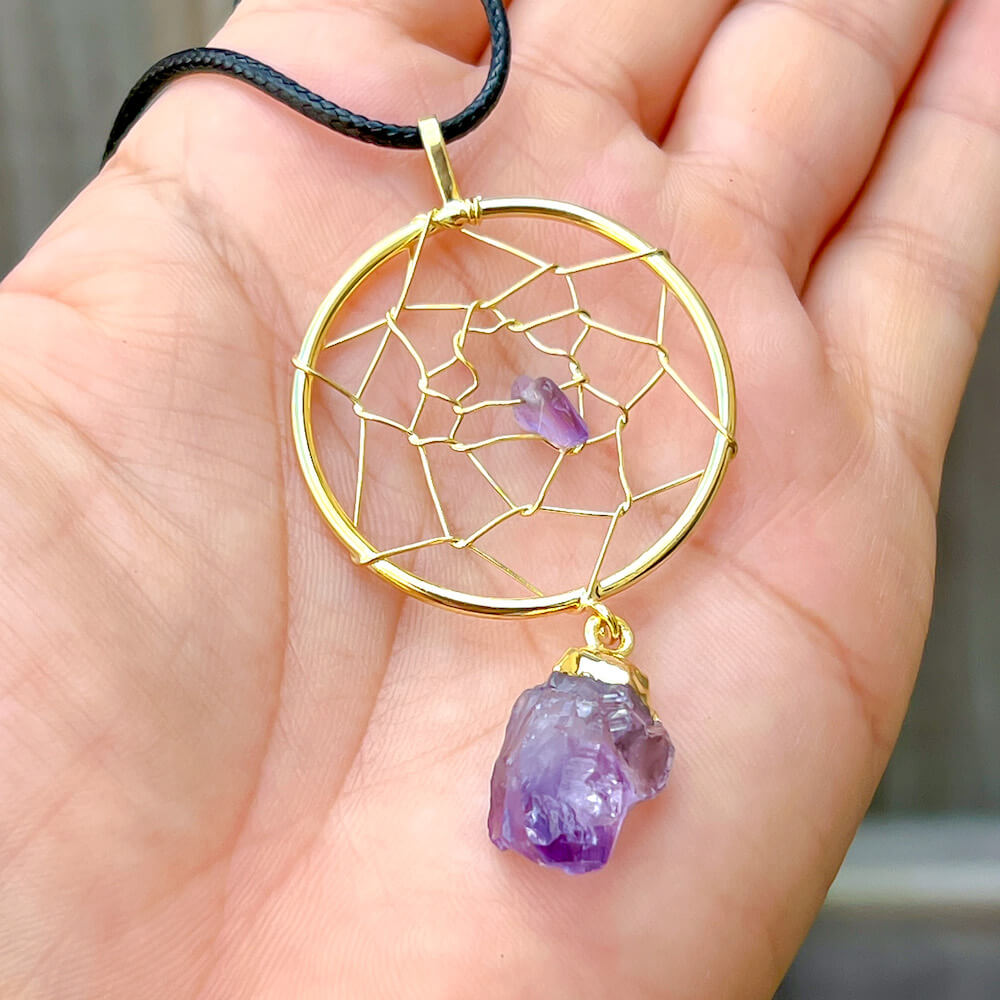 Gorgeous gold plated Amethyst Dreamcatcher gold Necklace adorned with an Amethyst crystal bead and a raw Amethyst crystal hanging from the bottom. Shop at Magic Crystals for Amethyst Jewelry, Healing Crystals, and Stones. Perfect gift for someone or to wear every day. Boho Jewelry, February Birthstone.